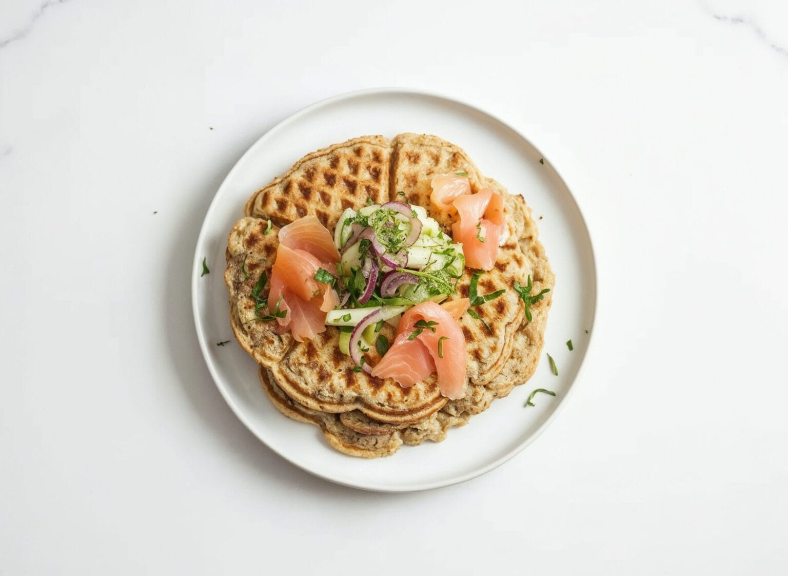 Kartoffelwaffeln mit Gurken-Fenchelsalat und frischen Kräutern angerichtet
