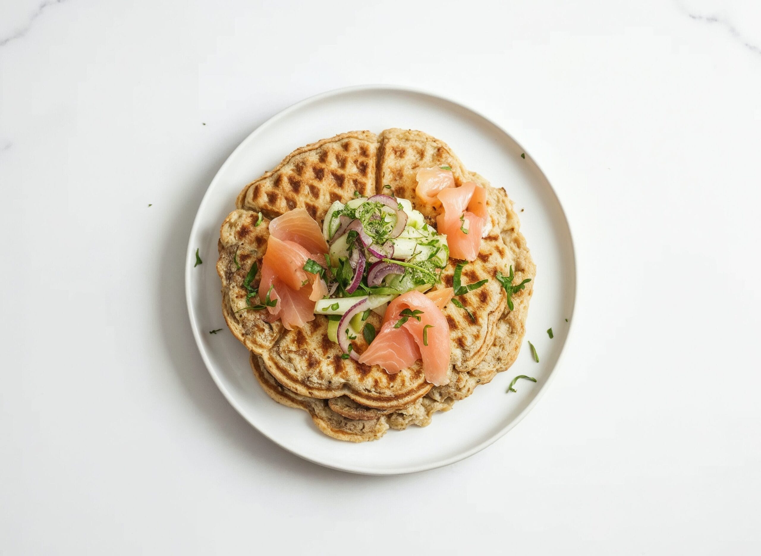 Kartoffelwaffeln mit Gurken-Fenchelsalat und frischen Kräutern angerichtet